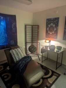 Soul Echo Therapy - Session Room (comfy lounge chair with a blanket, gong, and singing bowls, mandala painting on the wall)